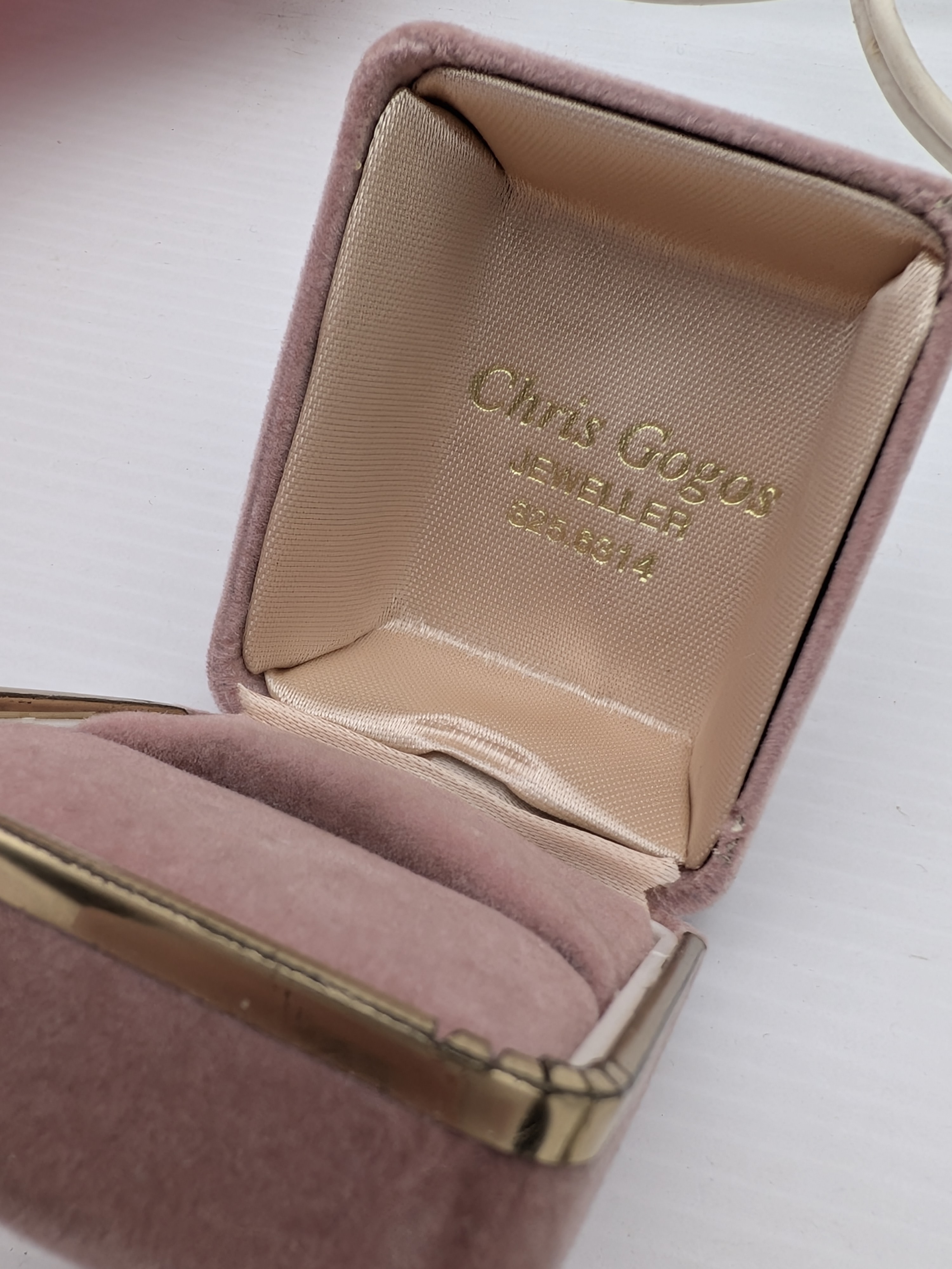 A charming collection of vintage decorative items, including a red art glass vase, a ceramic vase, a small hobnail glass table lamp, and a velvet jewellery box containing a silver-toned cameo necklace. - View 7