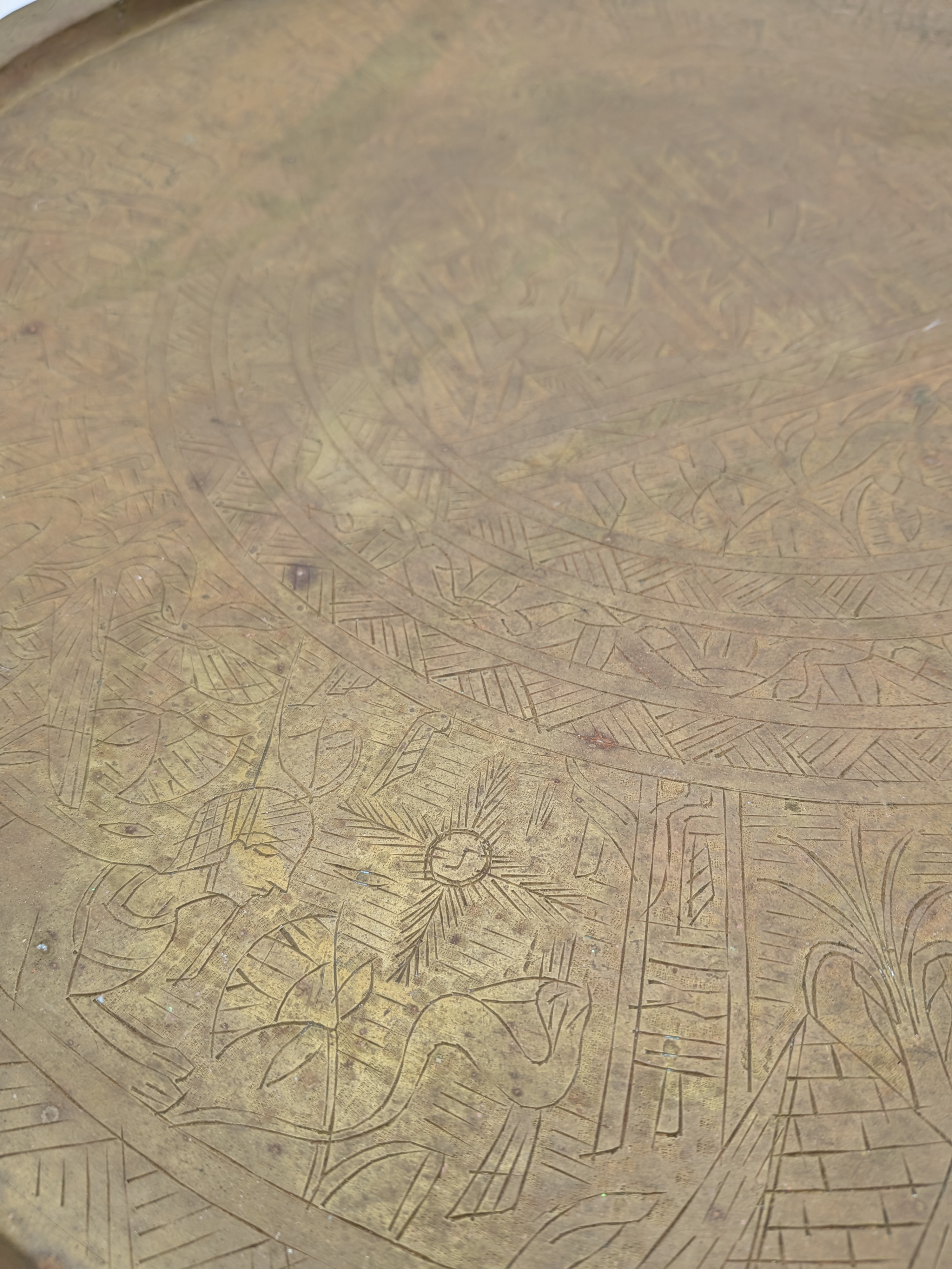 A substantial vintage etched brass tray, likely from the mid-20th century, showcasing traditional Middle Eastern or North African decorative metalwork. Its broad, circular form features intricate, deeply etched patterns across its surface, including figural elements, geometric motifs, and possibly calligraphic designs, characteristic of artisan craftsmanship from the region. - View 2