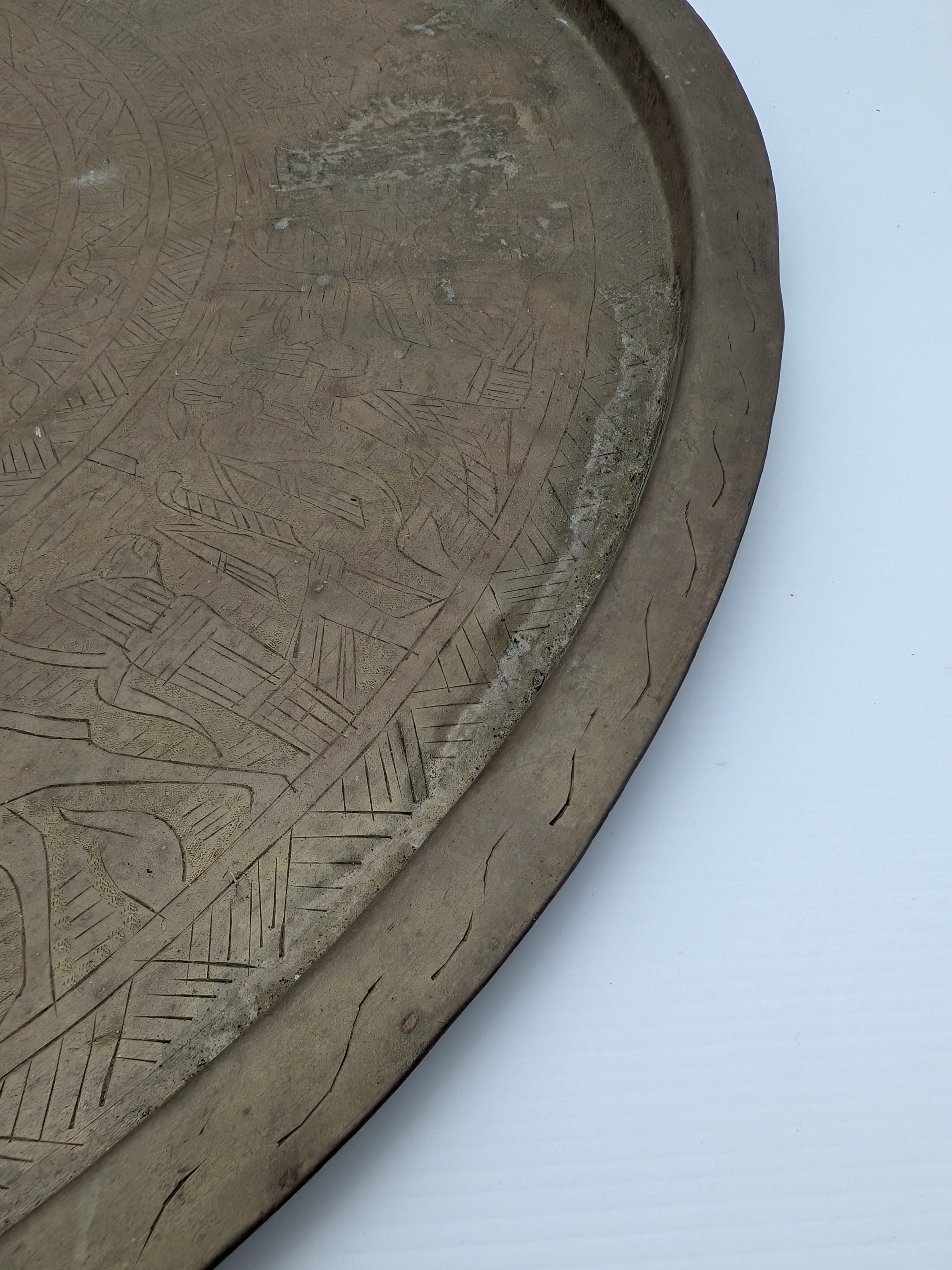 A substantial vintage etched brass tray, likely from the mid-20th century, showcasing traditional Middle Eastern or North African decorative metalwork. Its broad, circular form features intricate, deeply etched patterns across its surface, including figural elements, geometric motifs, and possibly calligraphic designs, characteristic of artisan craftsmanship from the region. - View 5
