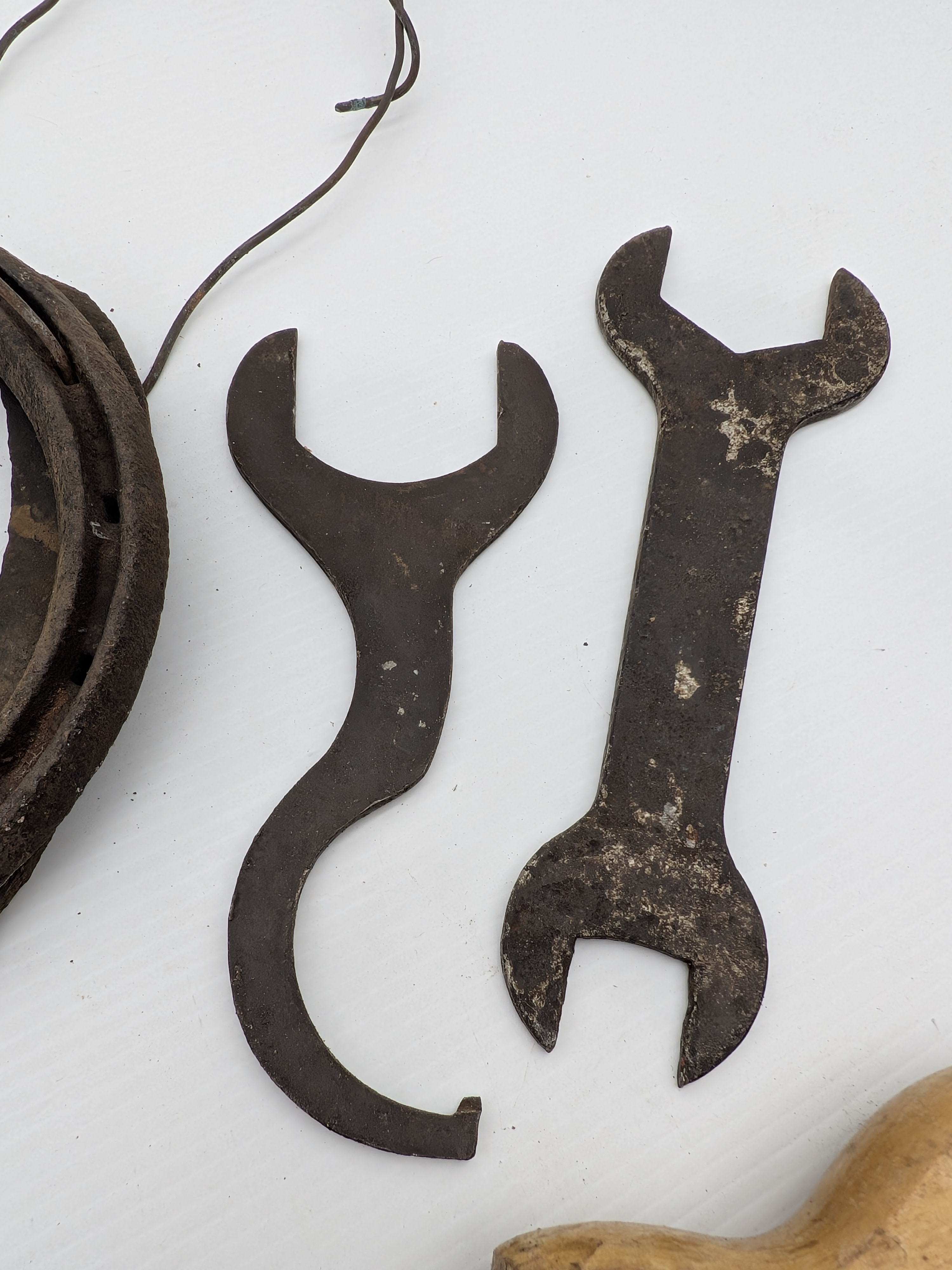 A comprehensive collection of vintage hand tools, including a Peugeot handsaw, assorted wrenches, pliers, pruning shears, horseshoes, and a bow saw frame, showcasing diverse forms and functions from the early to mid-20th century. - View 7