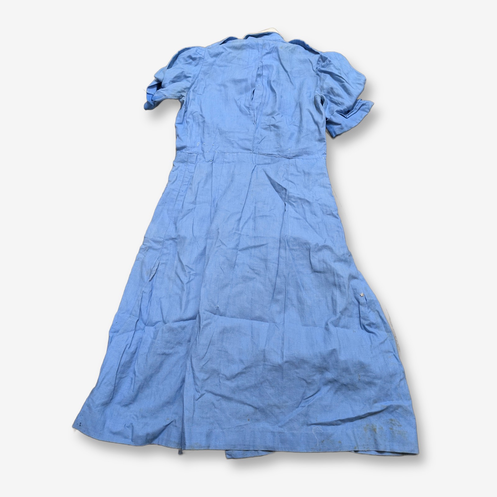 A vintage light blue nurse's uniform dress with a white collar and a red cross emblem, likely from the mid-20th century, made of cotton blend fabric. - View 2