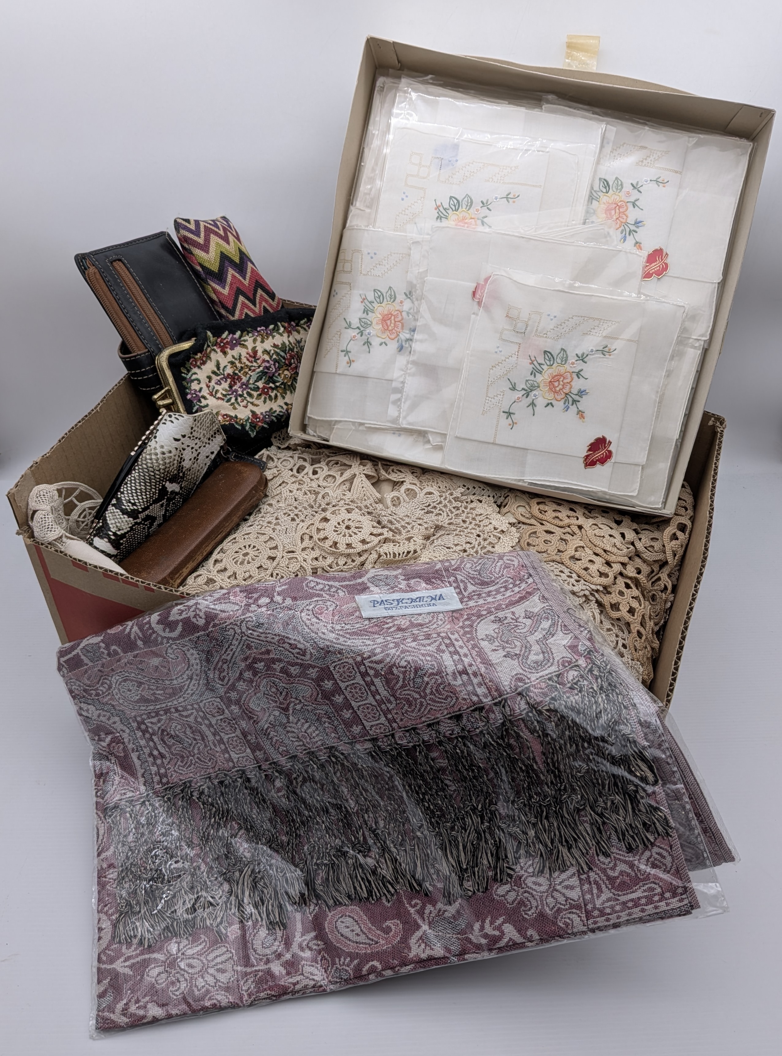 A diverse collection of vintage and contemporary household and personal accessories, including textile goods such as embroidered handkerchiefs, a pure pashmina shawl, and a quantity of crocheted lace, alongside several small leather and fabric purses and a spectacle case. - View 3