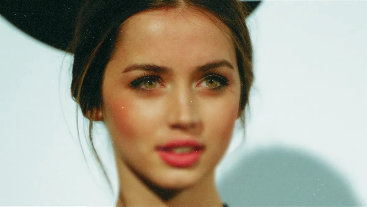 Ana de Armas in a close-up portrait with red lipstick and styled hair
