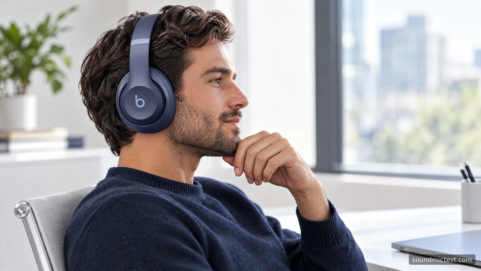 Navy Beats Studio Pro worn at a bright white office desk