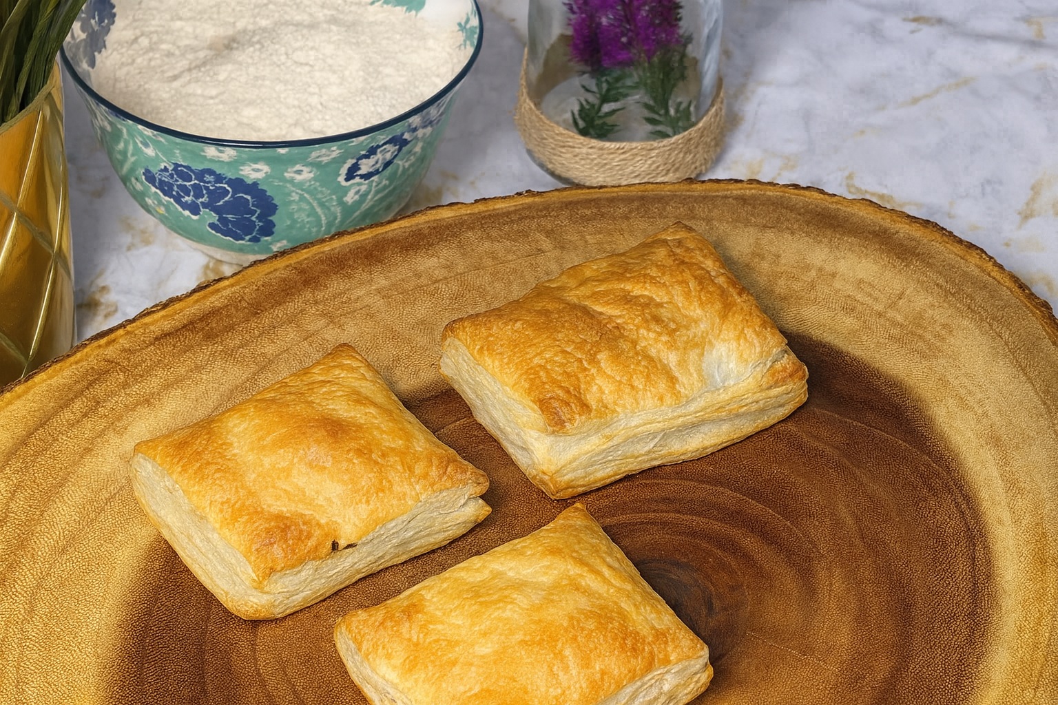 Golden flaky Indian potato puff pastries on a wooden board