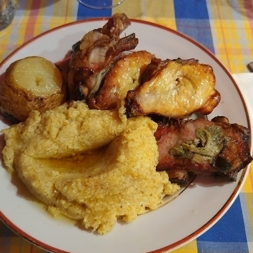 A plate of spiedo served with creamy polenta