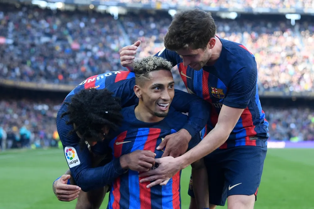 Raphinha header helps 10-man Barca to nervy Valencia win