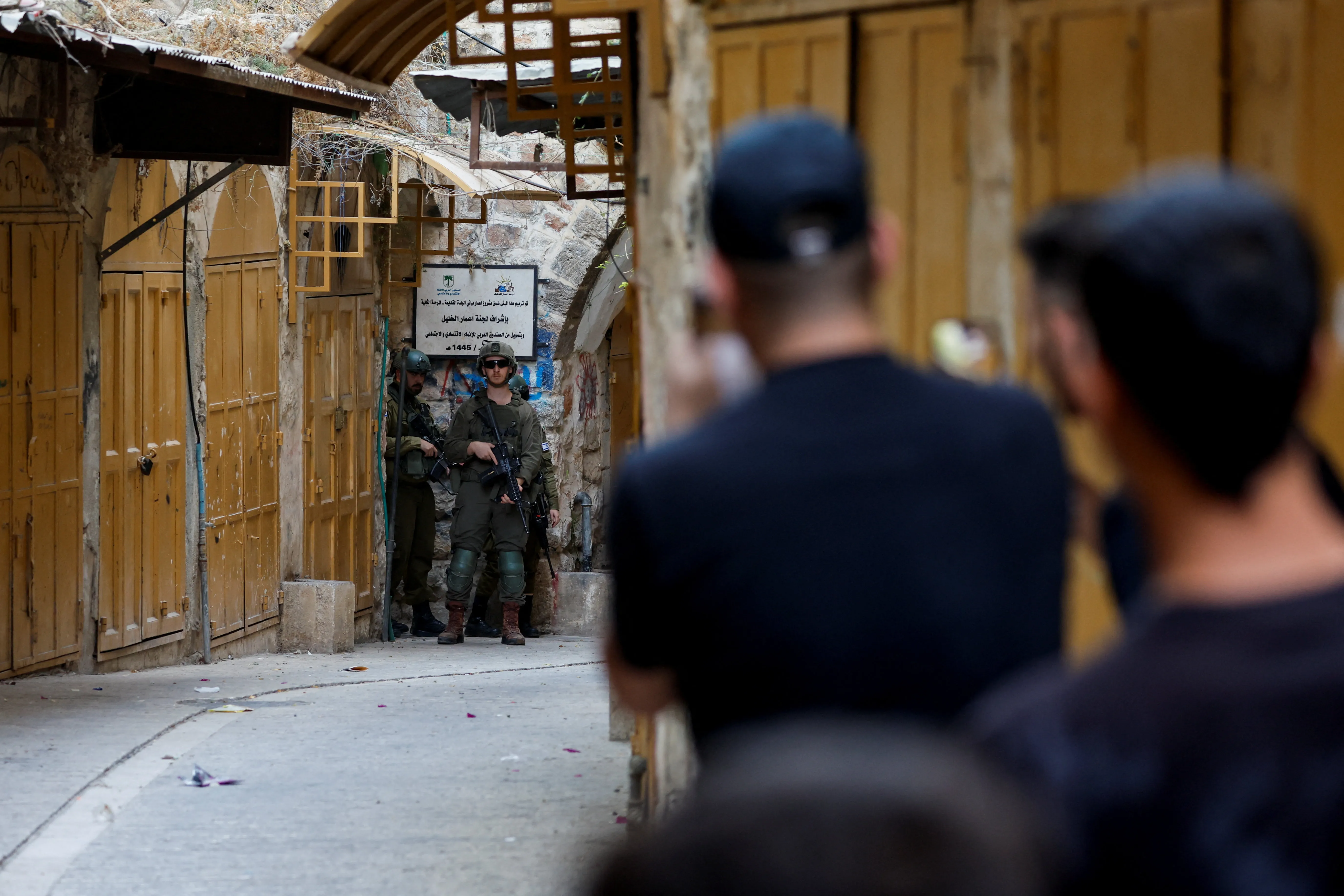 Israeli soldiers stand guard as they keep watch during Israeli settlers' weekly tour in Hebron, in the Israeli-occupied West Bank, August 29, 2026. REUTERS/Mussa Qawasma