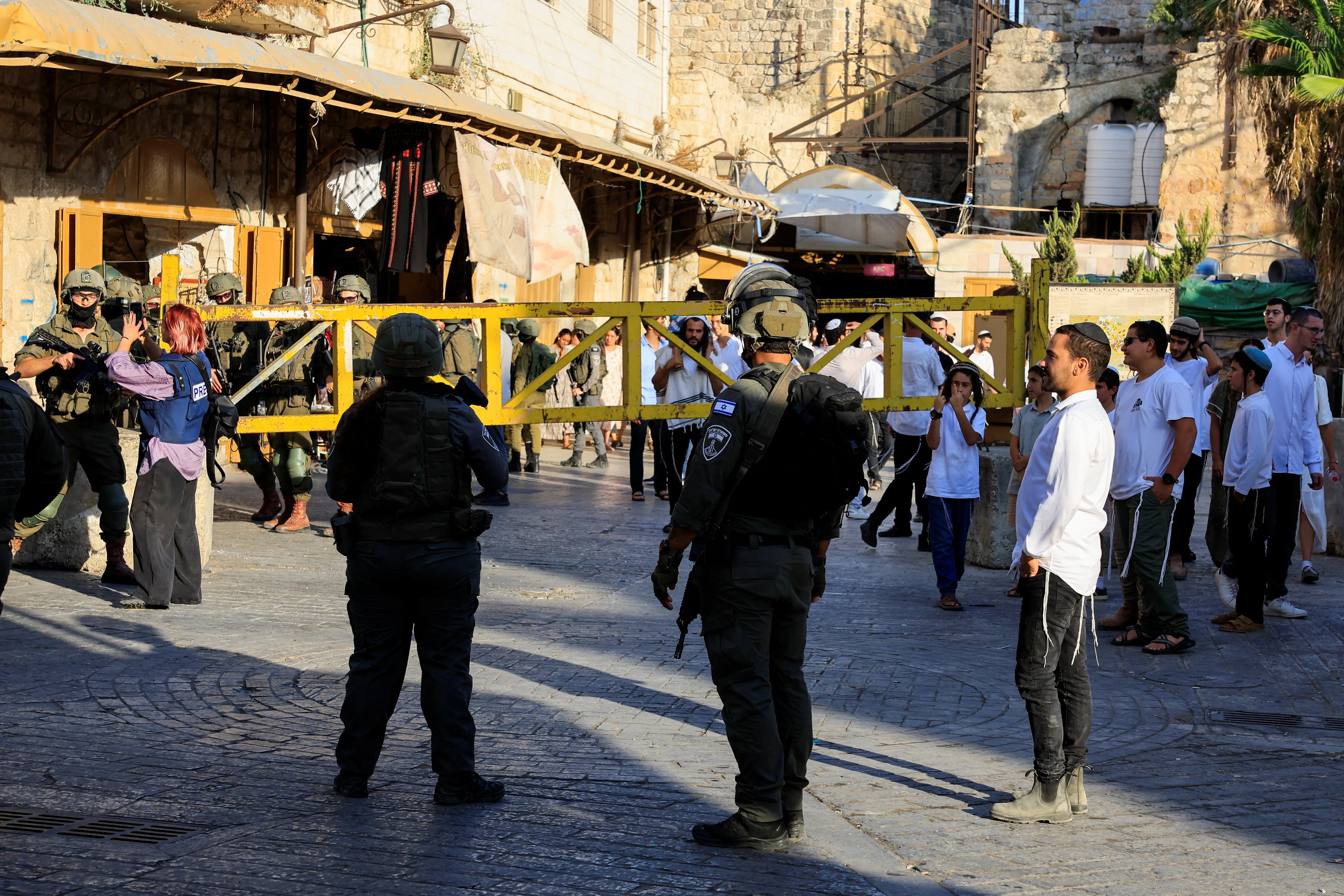 Israeli soldiers stand guard as they keep watch during Israeli settlers' weekly tour in Hebron, in the Israeli-occupied West Bank, August 29, 2026. REUTERS/Mussa Qawasma