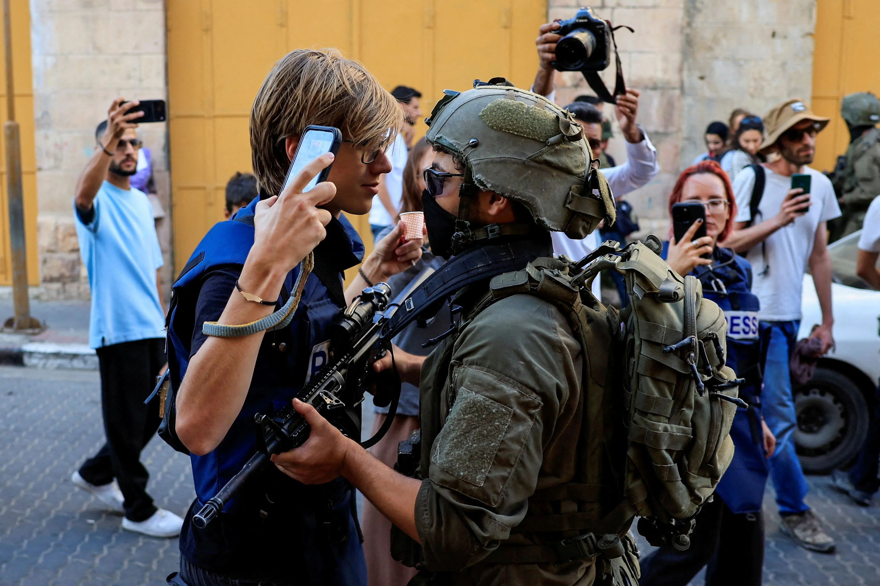 An Israeli soldier pushes a journalist, as Israeli security forces keep watch during Israeli settlers' weekly tour in Hebron, in the Israeli-occupied West Bank, August 29, 2026. REUTERS/Mussa Qawasma TPX IMAGES OF THE DAY