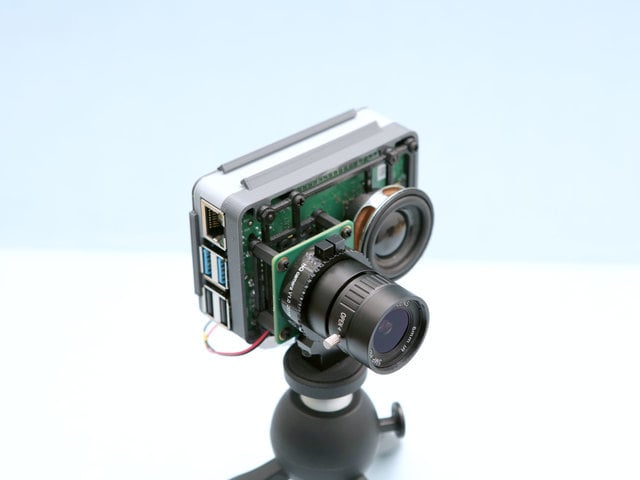 Raspberry Pi with a BrainCraft HAT and a camera module attached, mounted on a tripod. Visible ports include USB and Ethernet on the side.