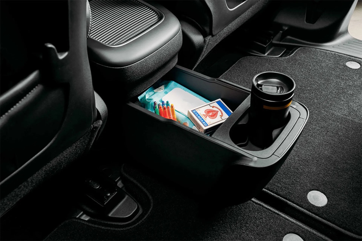 Console centrale arrière de la Chrysler Pacifica hybride 2026 avec espace de rangement et porte-gobelet, soulignant la praticité et l’ergonomie intérieure de la minifourgonnette.