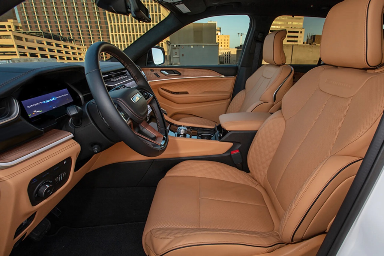 Habitacle du Jeep Grand Cherokee 2026 avec sièges en cuir brun, tableau de bord numérique et finitions haut de gamme axées sur le confort et la technologie.