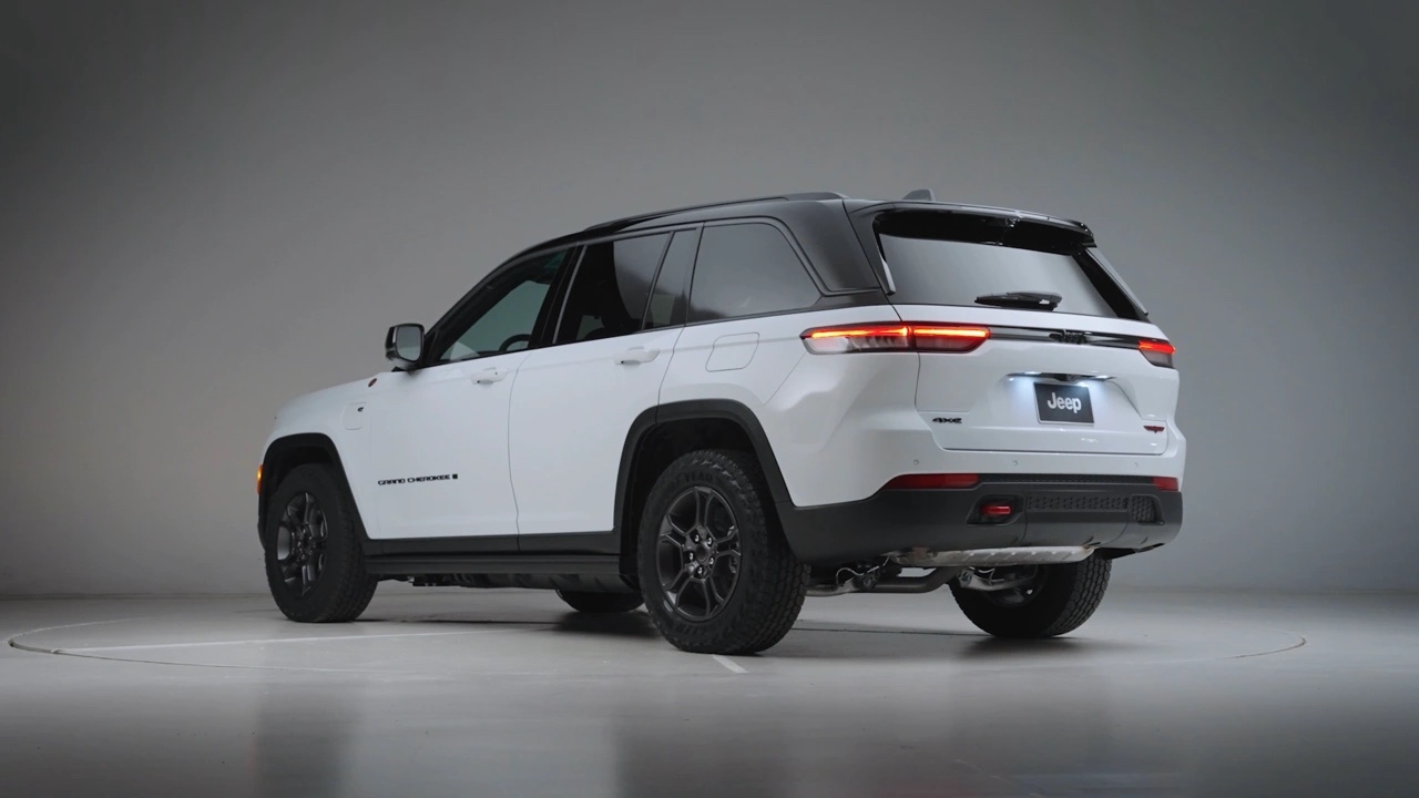 Vue arrière trois quarts du Jeep Grand Cherokee 2026 blanc en studio, montrant les feux arrière à DEL, le hayon et la silhouette dynamique du VUS.