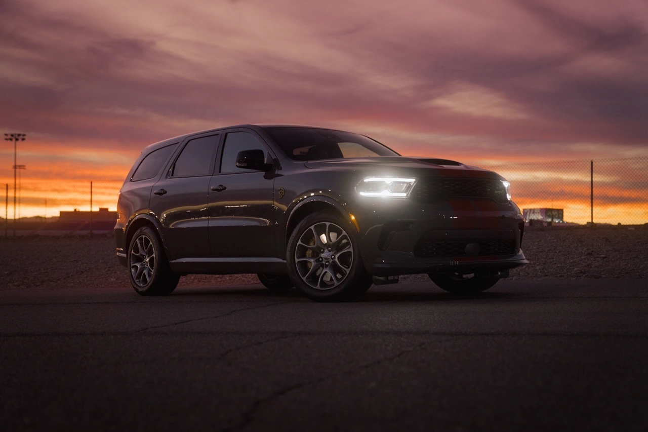 Dodge Durango 2026 gris vu de trois quarts avant au coucher du soleil, mettant en évidence les phares à DEL, les jantes sport et le design agressif.