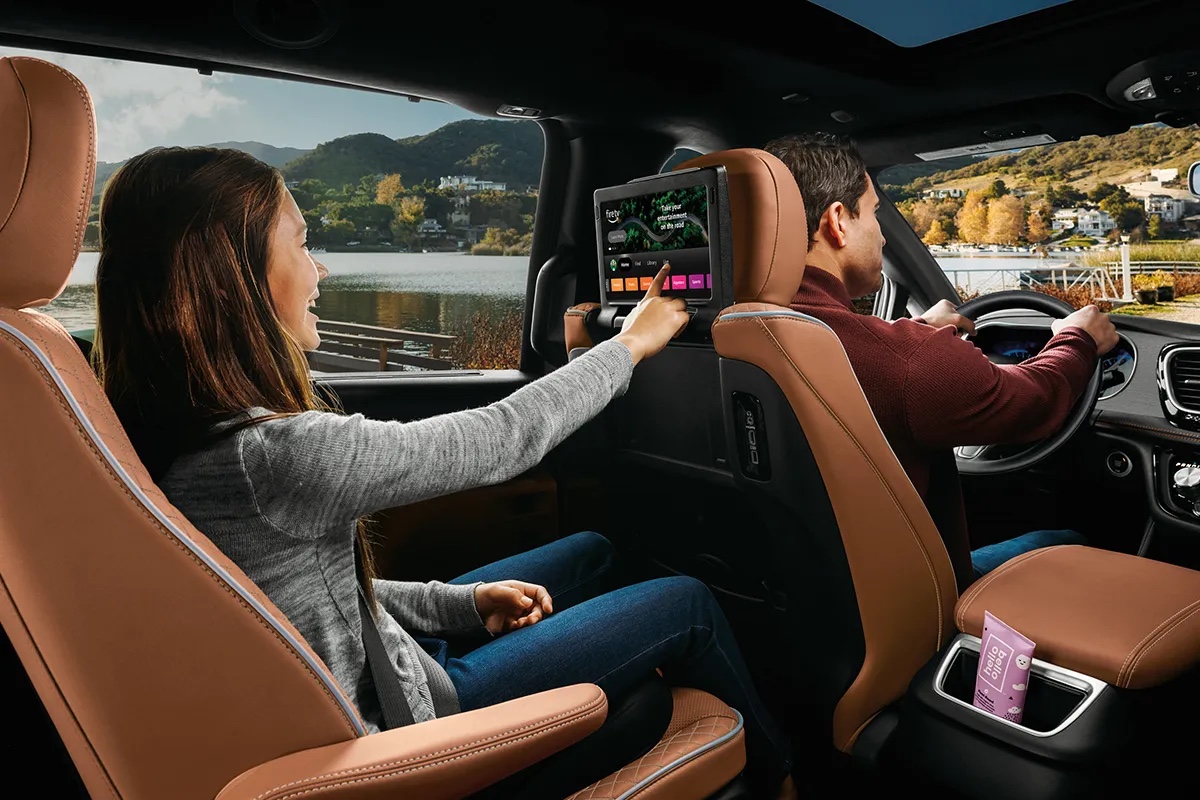 Passager arrière utilisant l’écran multimédia Amazon Fire TV dans la Chrysler Pacifica hybride 2026, illustrant les technologies de divertissement pensées pour les familles.