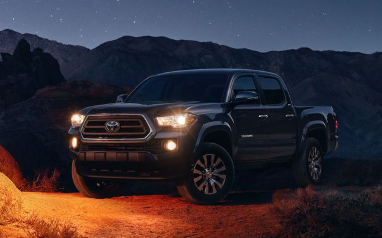 La Toyota Tacoma stationné pour la nuit lumières allumées.