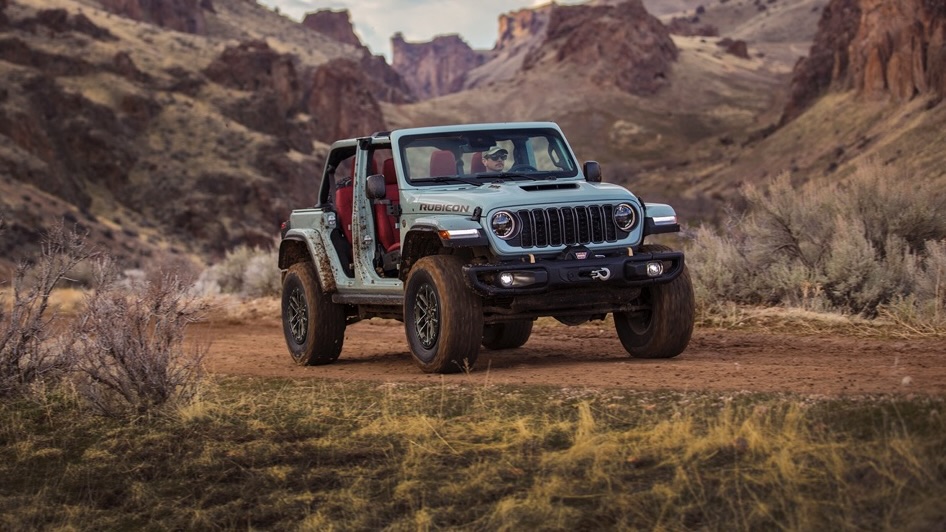 Le Jeep Wrangler 2024 sur un chemin de terre entre les montagnes.