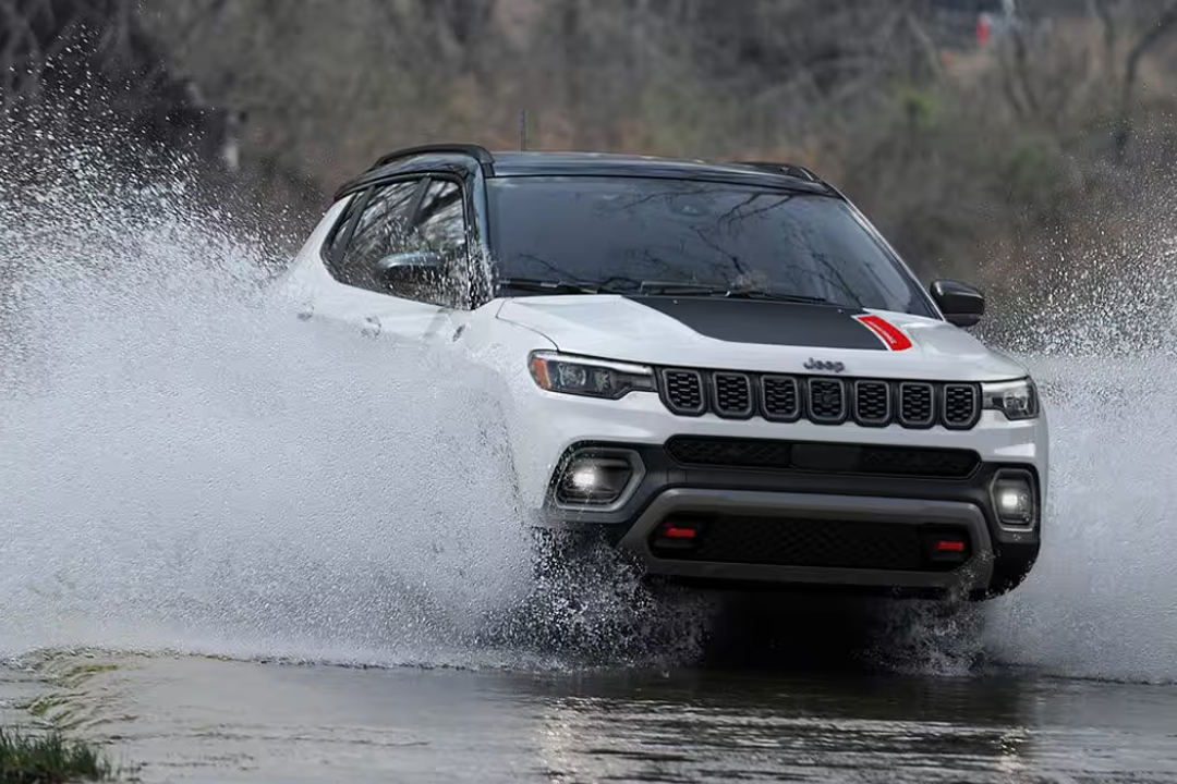 Vue 3/4 avant du Jeep Compass 2024 traversant une marre d'eau