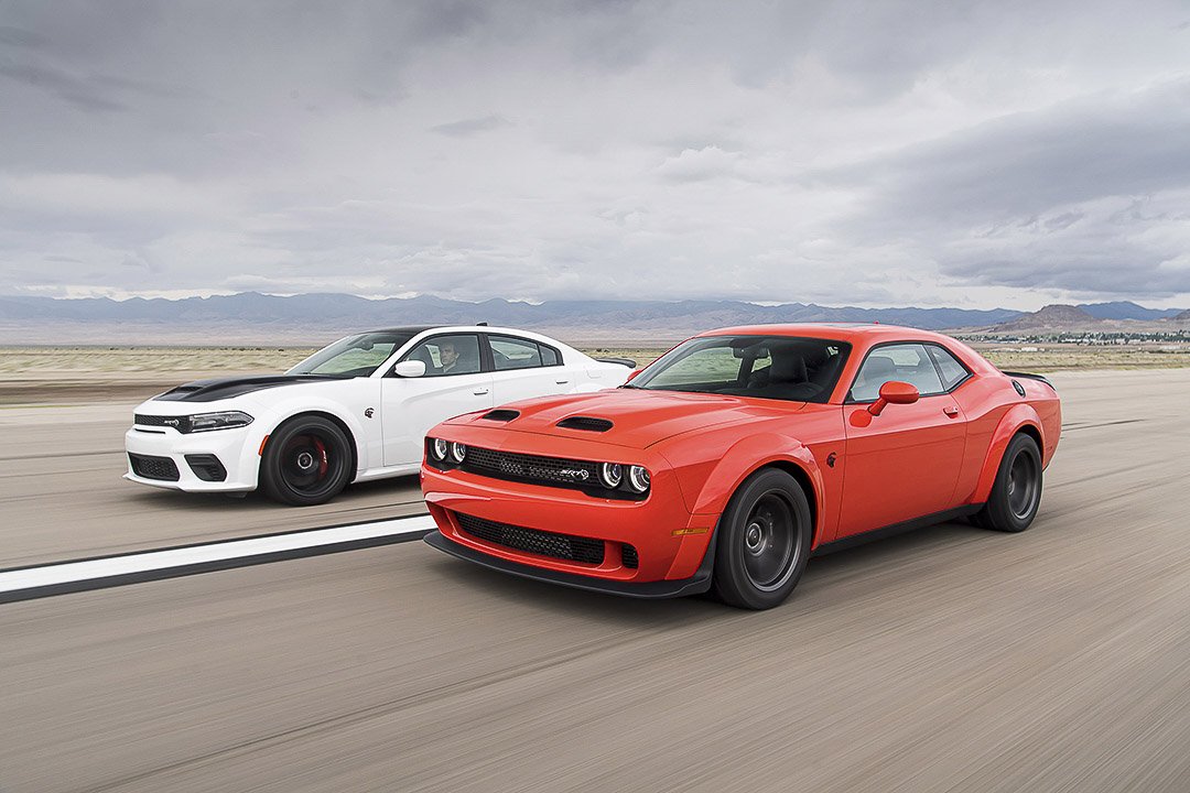 Vue 3/4 avant et latérale d'un Dodge Charger et challenger sur circuit en pleine puissance