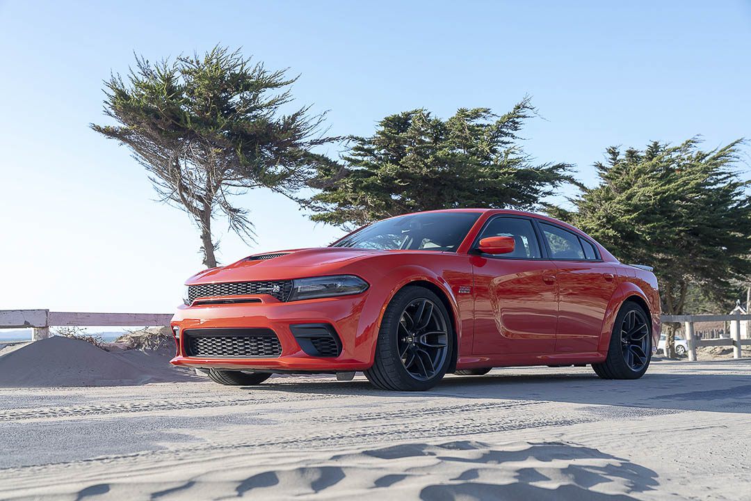 Vue 3/4 avant et latérale du Dodge Charger 2022 sur route de sable et plage