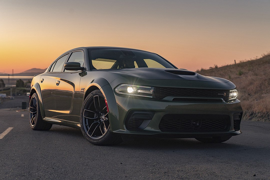 Vue 3/4 avant et latérale du Dodge Charger 2022 sur route avec coucher de soleil