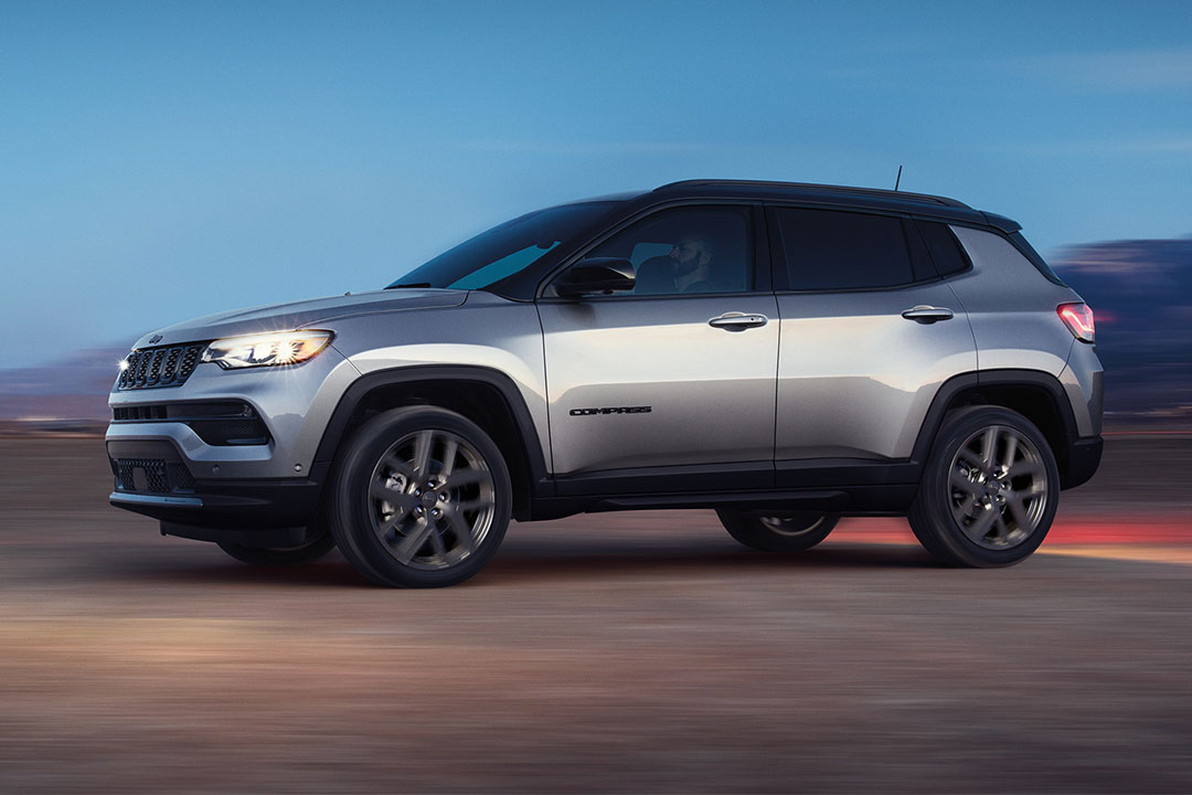 Un profil latéral d’un Jeep Compass 2024 gris conduisant.