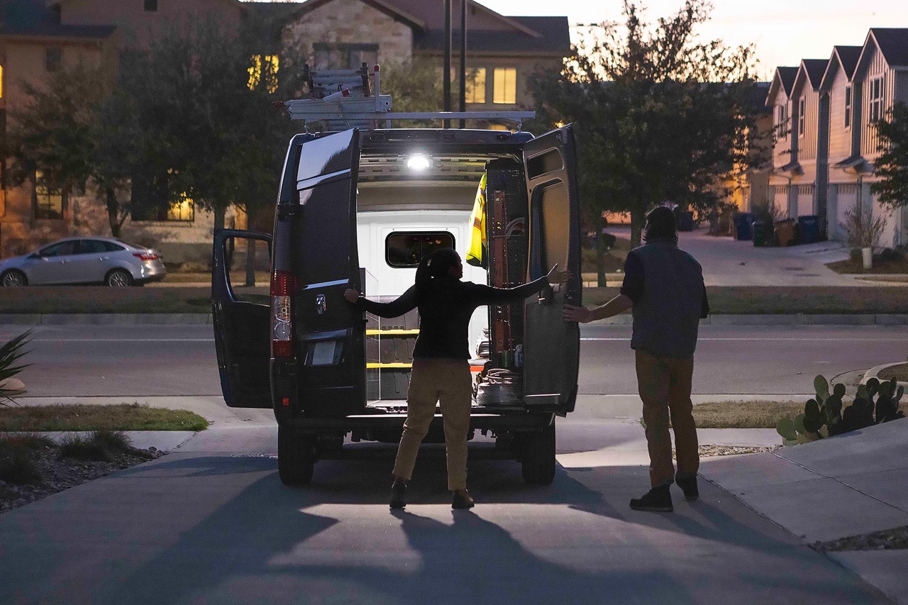 Vue arrière du Ram ProMaster 2026 de nuit avec portes ouvertes et éclairage intérieur, montrant l’accès au compartiment utilitaire résidentiel.