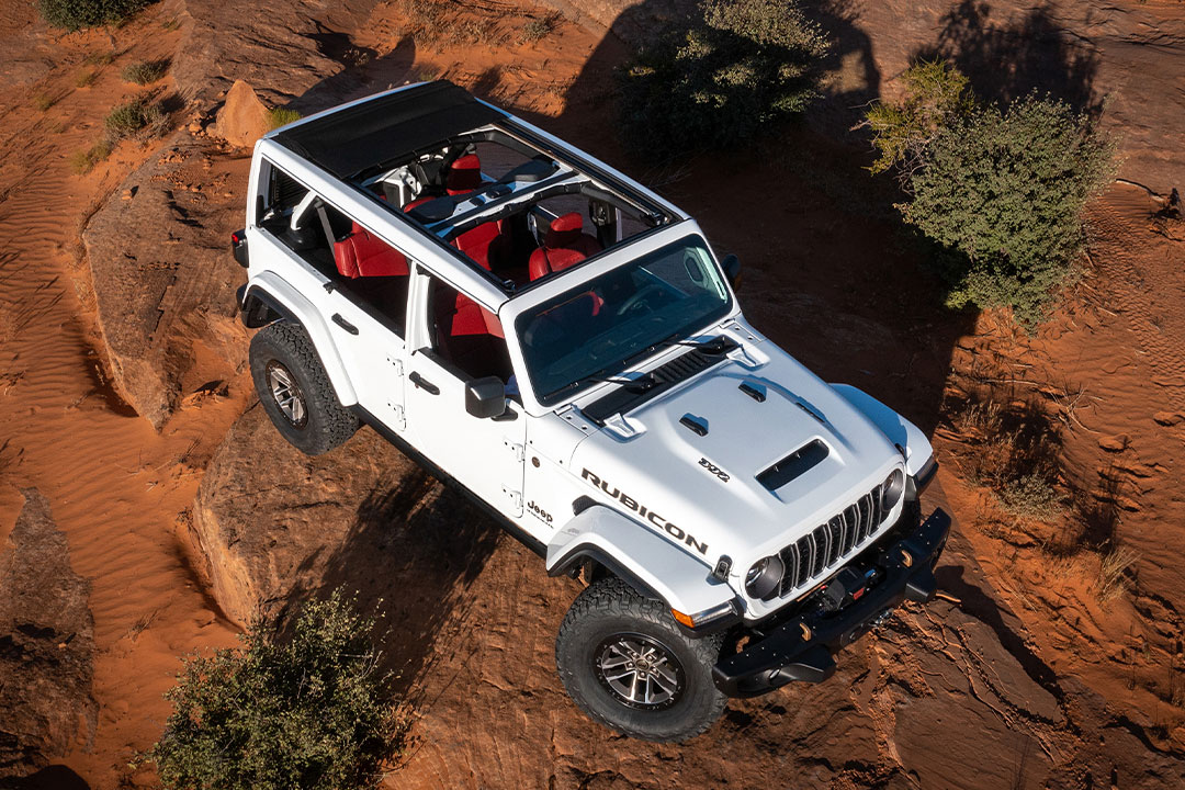 Vue aérienne du Jeep Wrangler Rubicon 2024 avec toit ouvert, traversant une colline escarpé