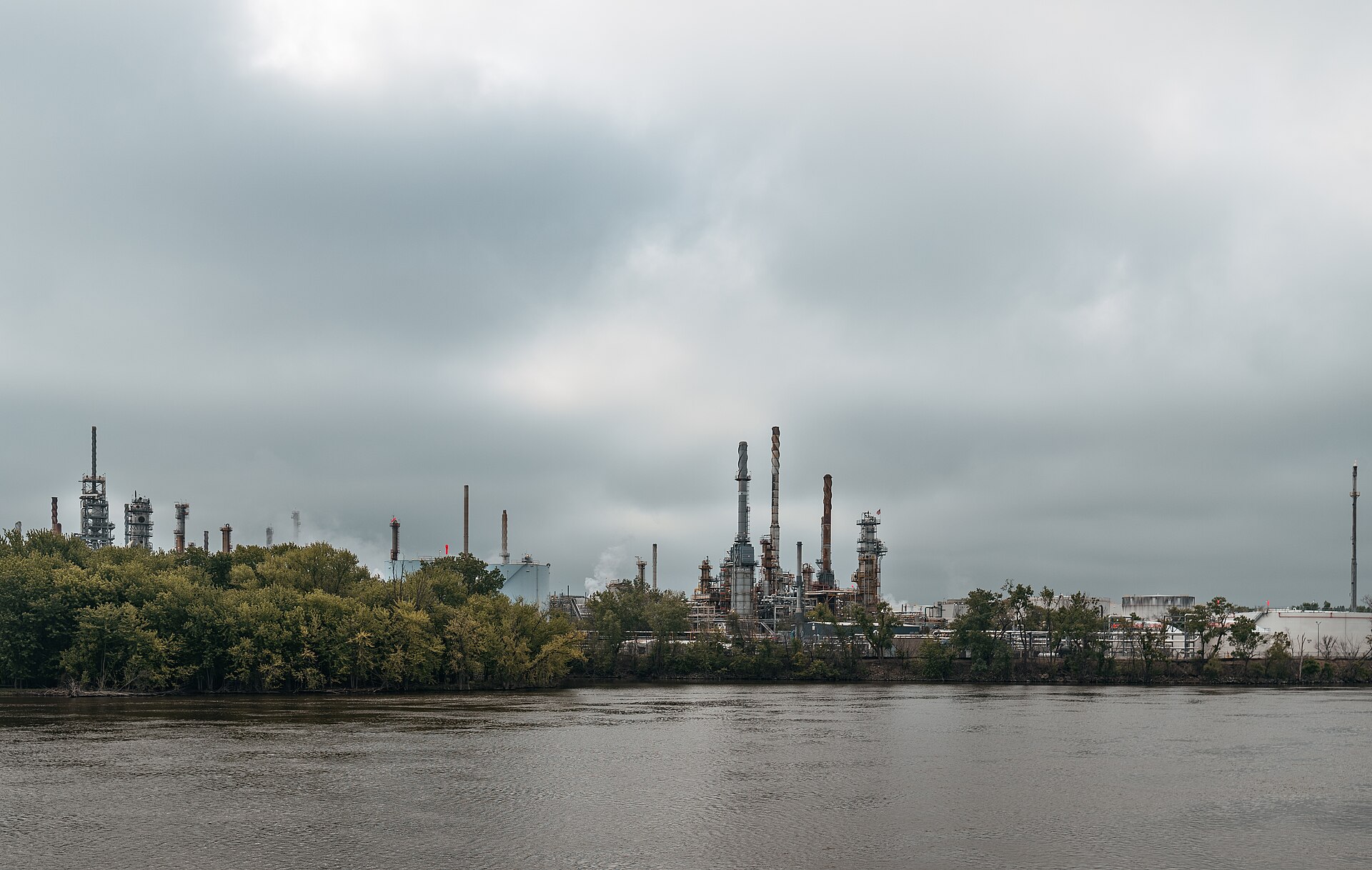 View across the Mississippi River toward refinery towers and tanks at St. Paul Park.