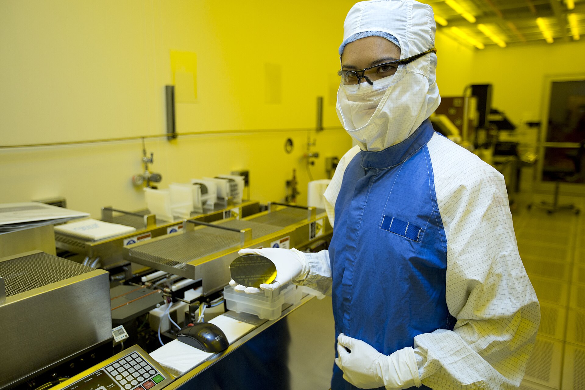 Researcher in a laboratory holding a silicon wafer