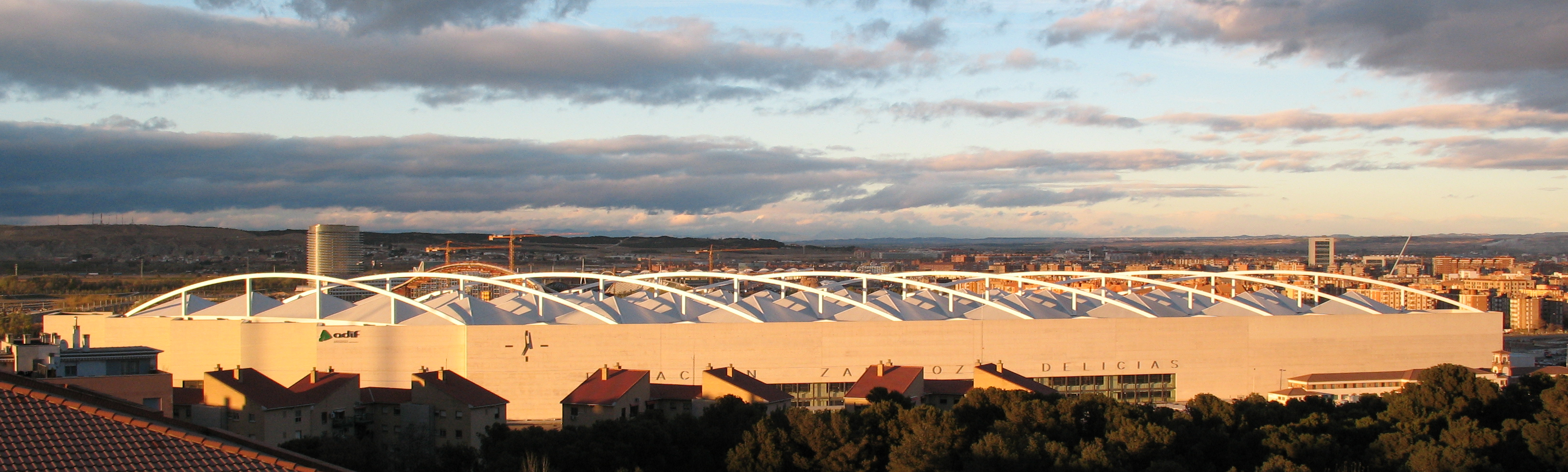 Panoramic view of Zaragoza-Delicias station with the old Las Delicias station visible in the foreground, linking the route's two railway eras.