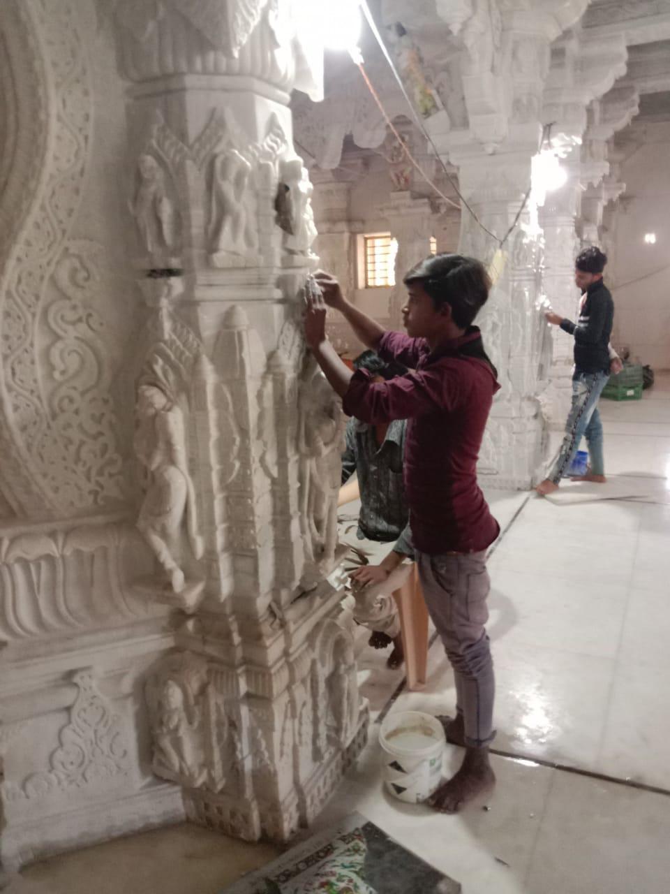 Worker polishing a finished marble statue to a high shine.