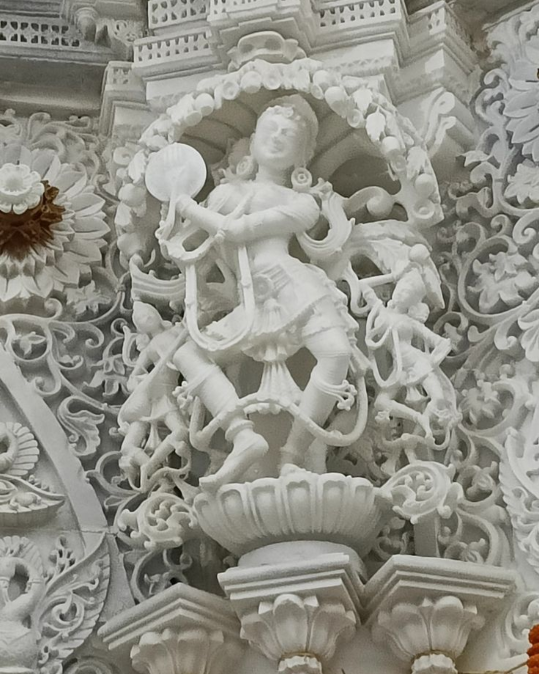 Two craftsmen discussing blueprints over a block of marble.