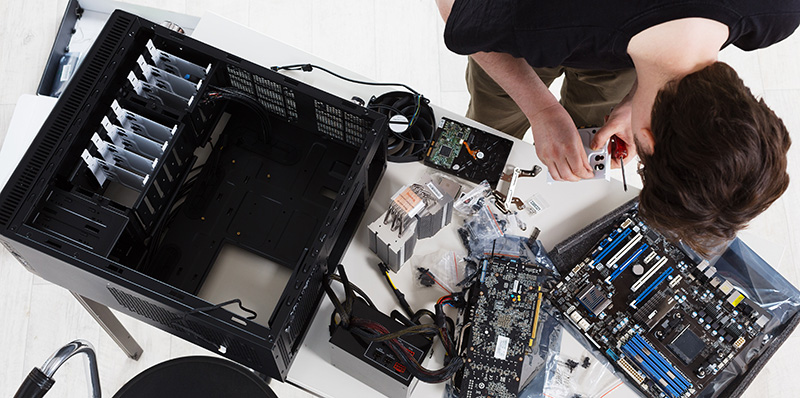 Сервис за Компјутери и Лаптопи - A technician cleaning a dusty computer fan.