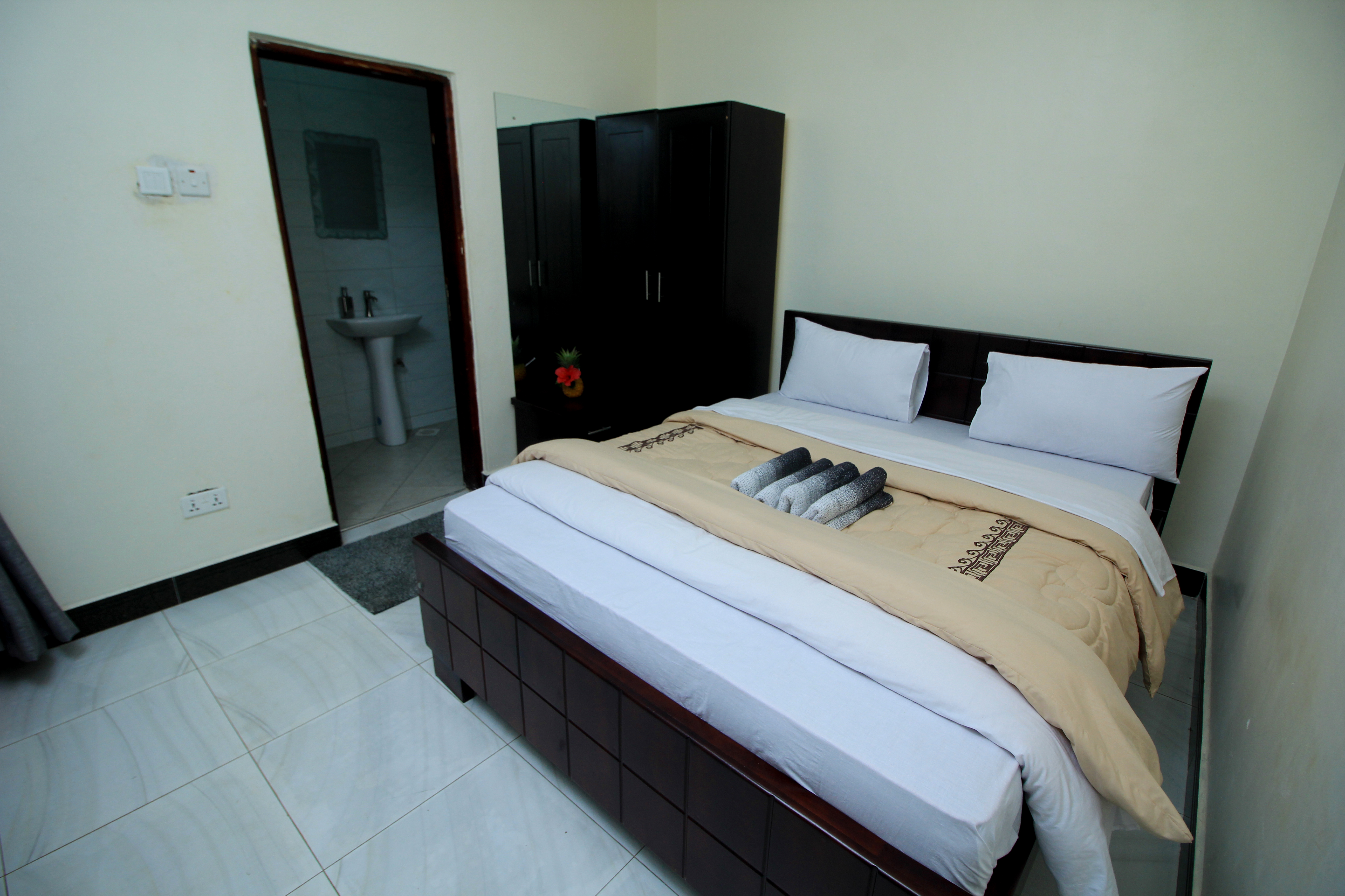 A beautifully appointed modern hotel room with a balcony view of the forest.