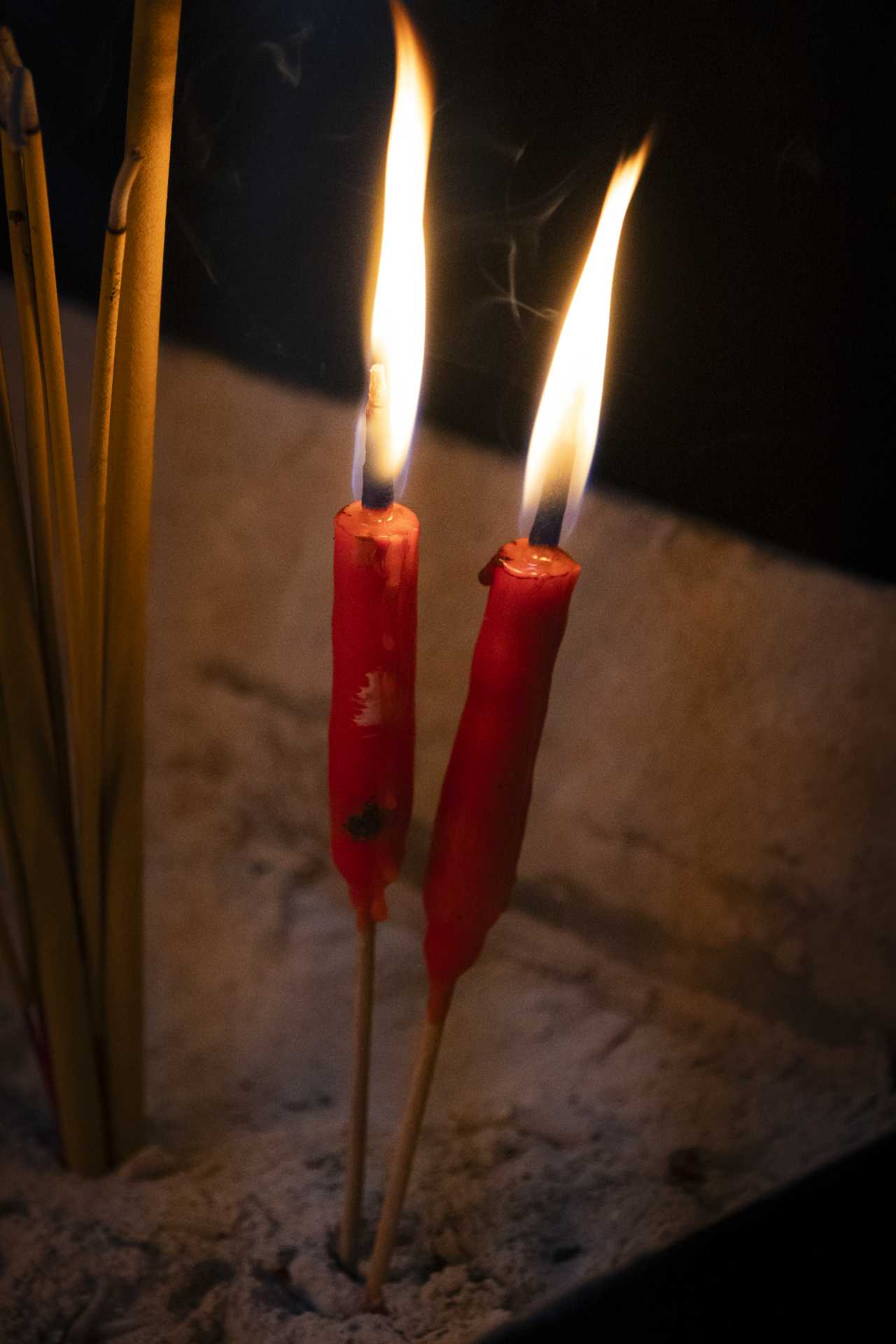 Two red candles burning in a temple.