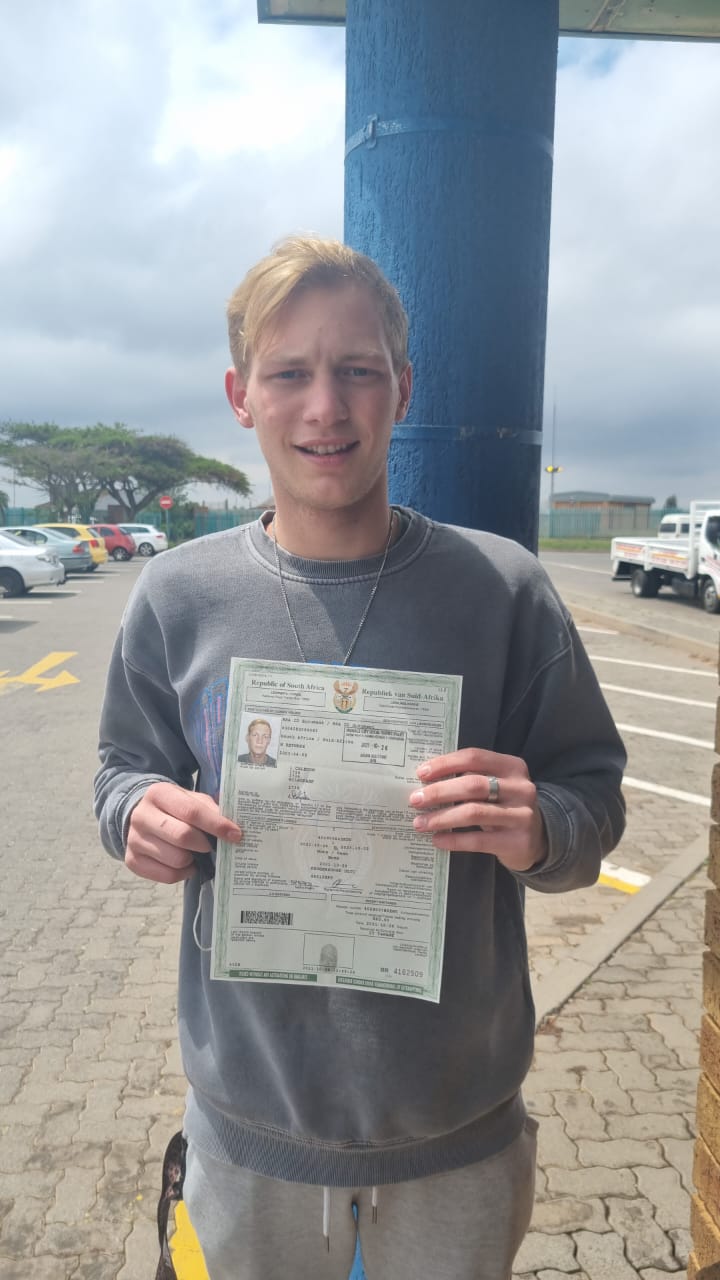 Happy student holding a driver's license.