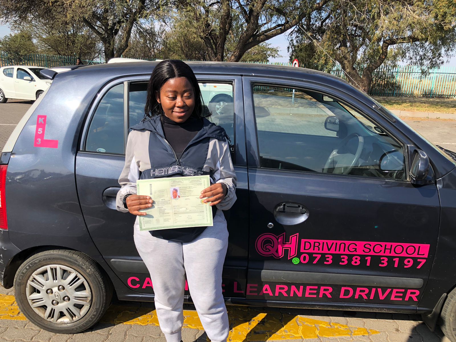 A learner driver focused on the road, seen from the passenger seat.