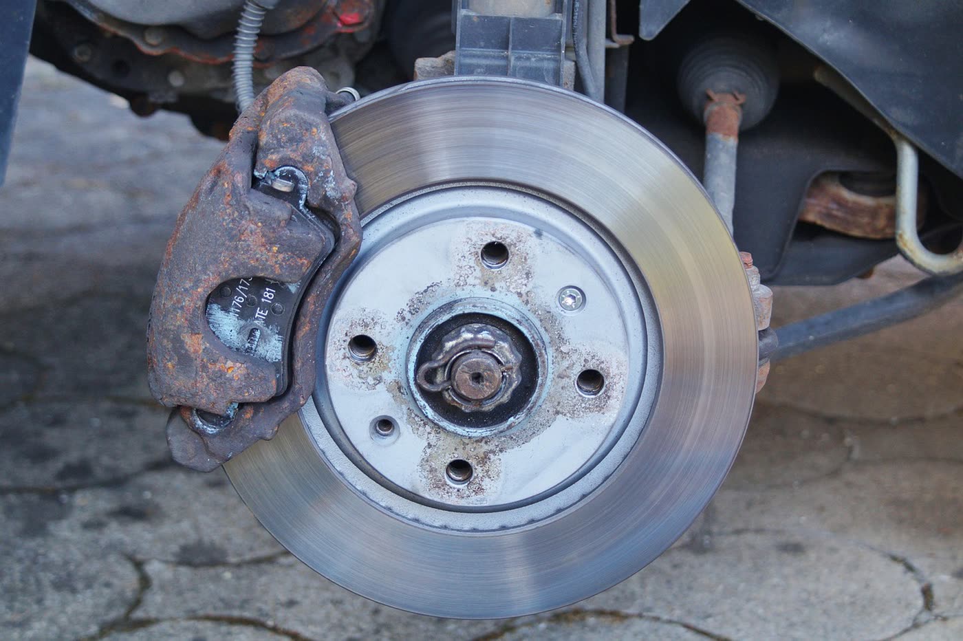 Disco de freno y pinza de un coche con restos de polvo de frenada