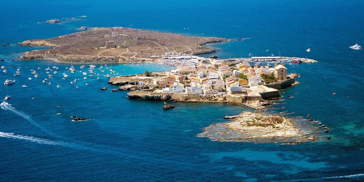 Un precioso velero en las aguas cristalinas cerca de la Isla de Tabarca, ideal para una excursión.