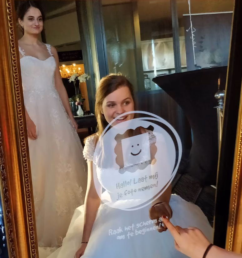 Bruid start haar fotosessie op het touchscreen van de Mirrorbooth