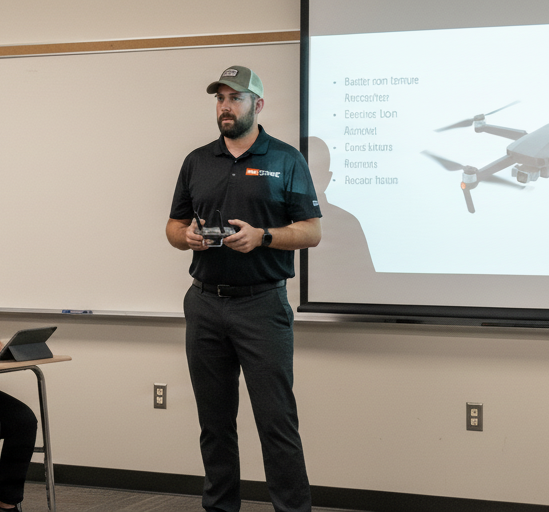 A person learning to fly a drone in an open field.
