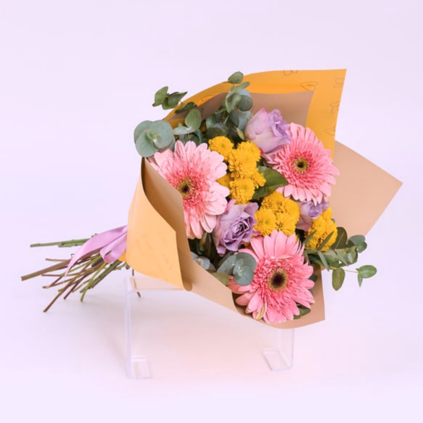 Gerberas rositas, rosas moradas y margaritas amarillas en ramo