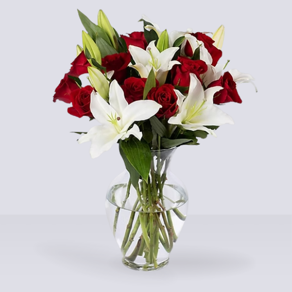 lilis blancas y rosas rojas en florero