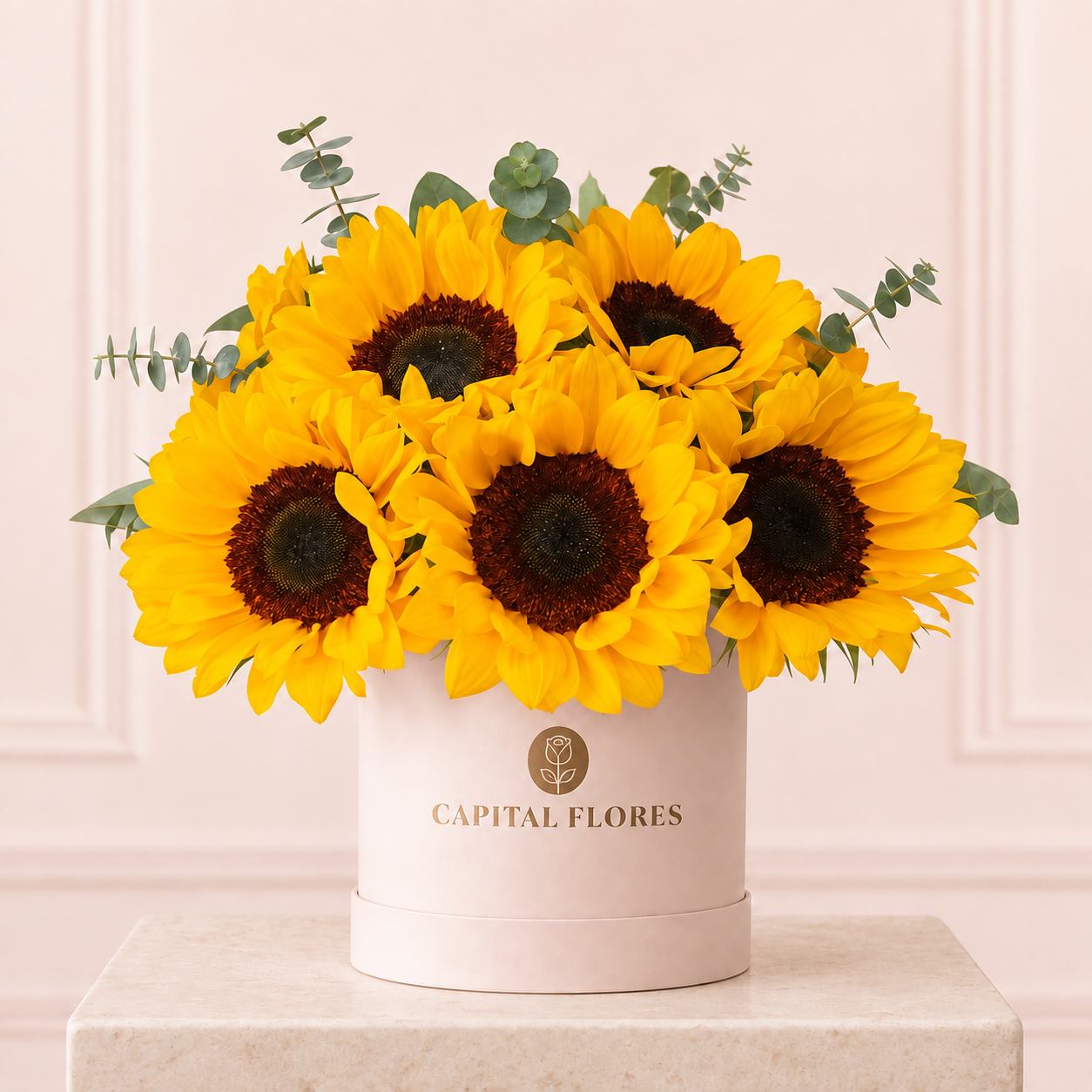 Girasoles con eucalipto en caja redonda rosa