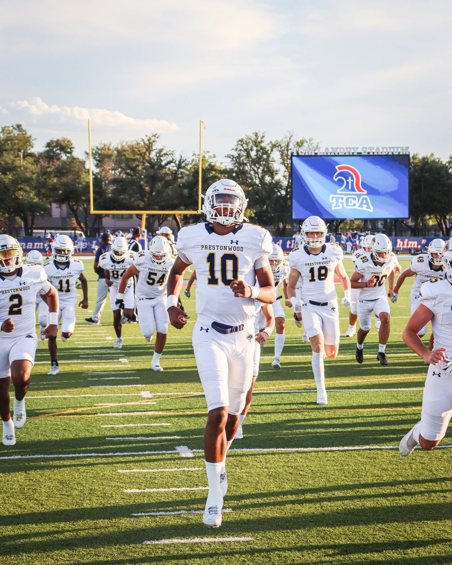 Prestonwood's number ten leads the team onto the field past the TCA scoreboard.