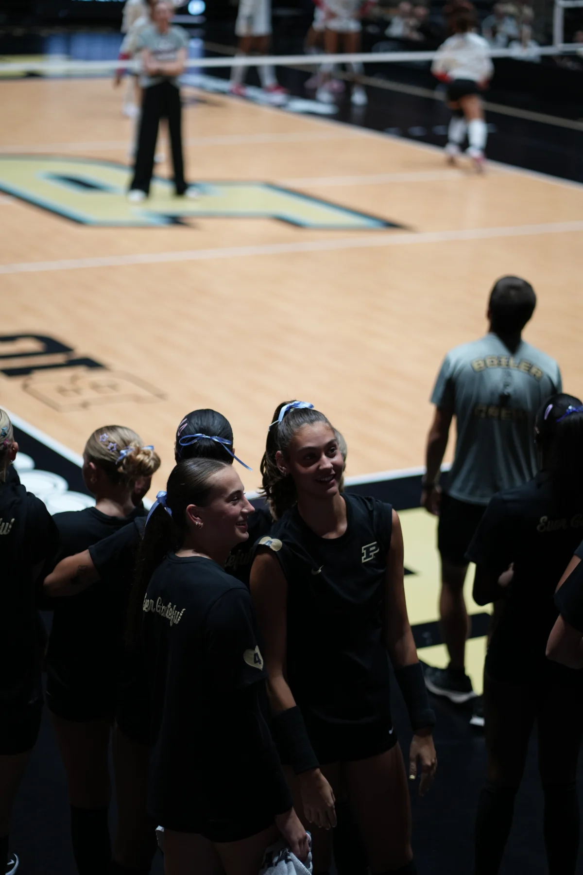 Players gather courtside in warmups, smiling, before the first serve at Purdue.