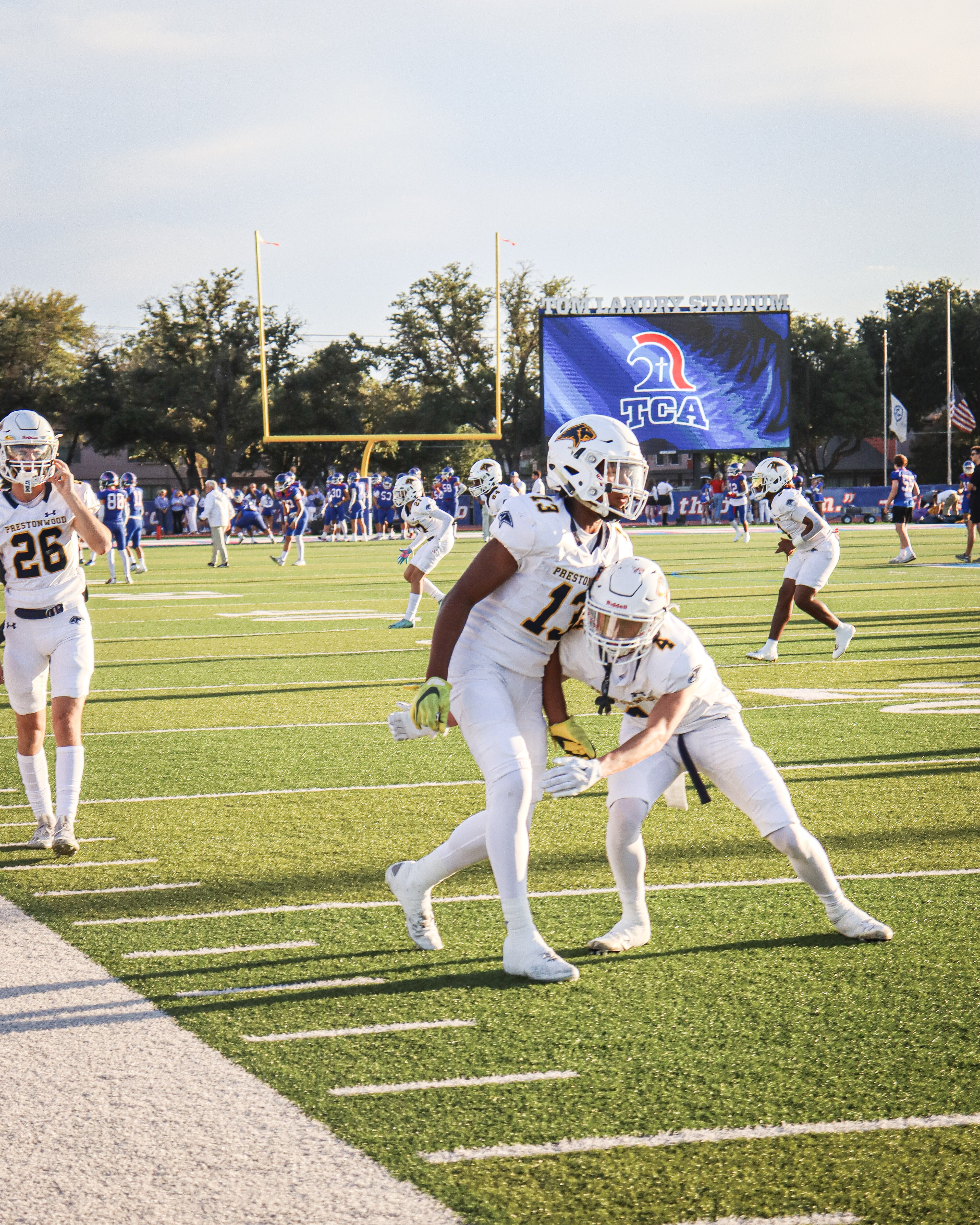 Two Prestonwood players work through a warmup drill in front of the TCA scoreboard.