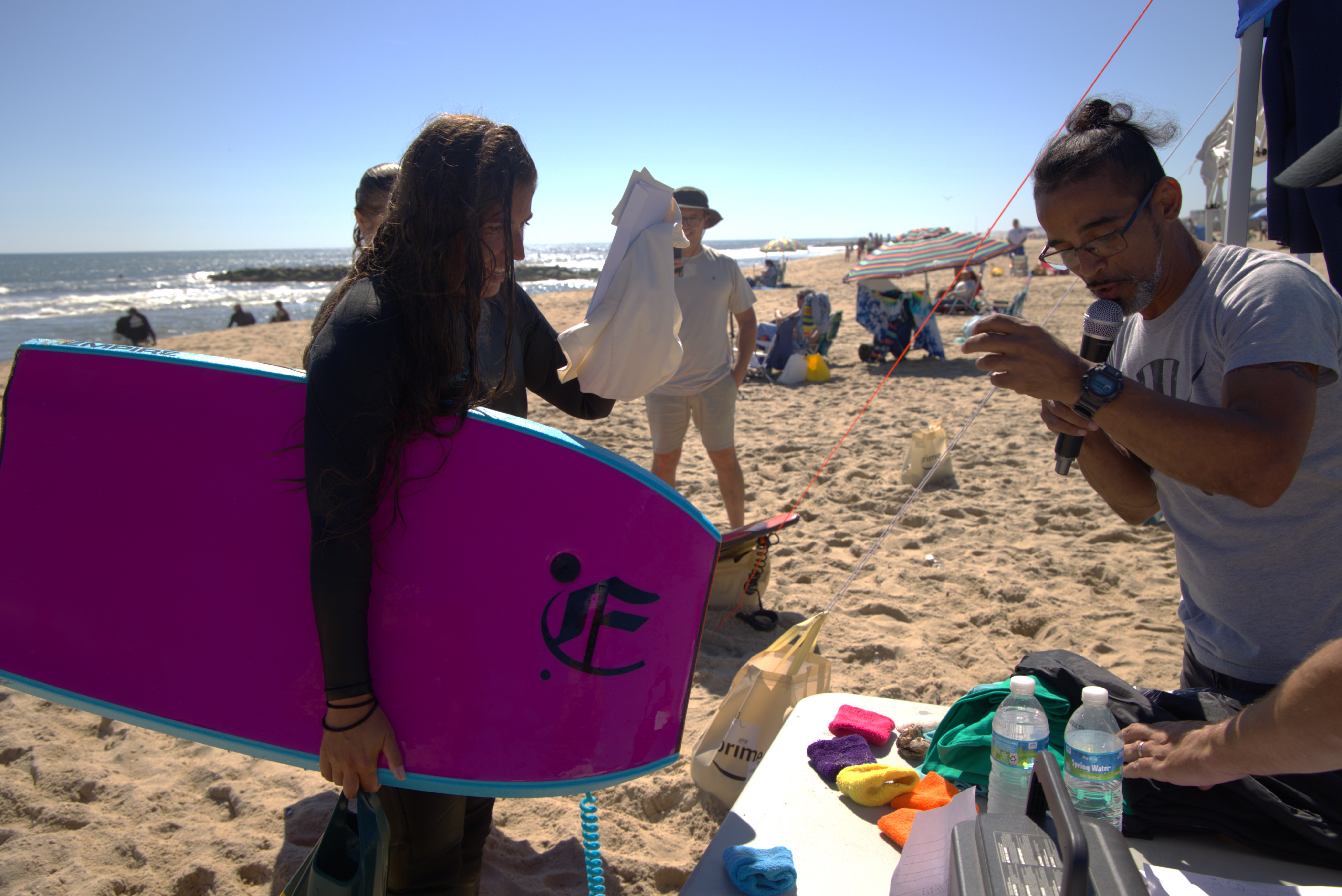 A bodyboarder posing with his board on the beach.
